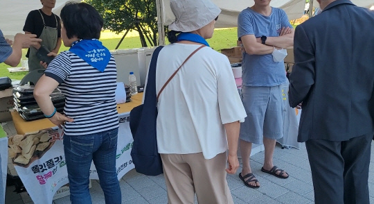 7일 오후 더불어민주당 지지자들 일부가 국회 소통관 앞 판매 행사장을 방문해 항의하고 있다. 안소현 기자